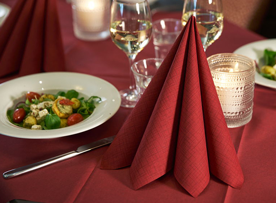 Red Dunilin® linen feel napkins on a red table cover for Christmas