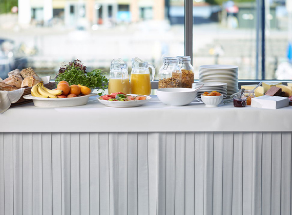 Breakfast buffet table with white table skirt and banquet roll